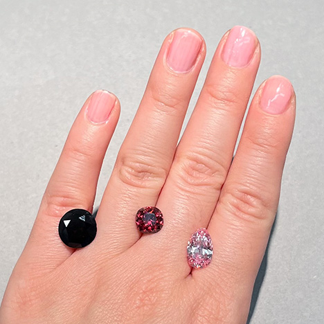 Figure 3. The Winston Red diamond (center, 2.33 ct), alongside the much darker “red-brown” DeYoung Red (left, 5.03 ct) and the DeYoung Pink diamonds (right, 2.82 ct). All three stones are currently on public exhibit at the Smithsonian NMNH. Photo by Gabriela Farfan.