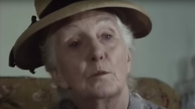 Joan Hickson's Miss Marple wearing a beige hat and looking thoughtful on Miss Marple