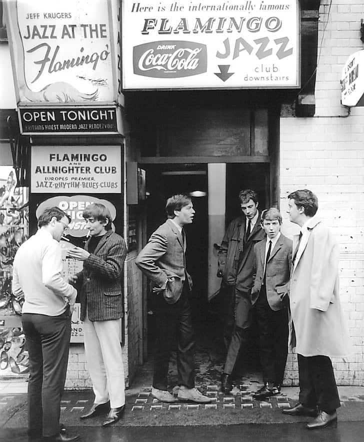 a group of men in 1964 standing outside a jazz club